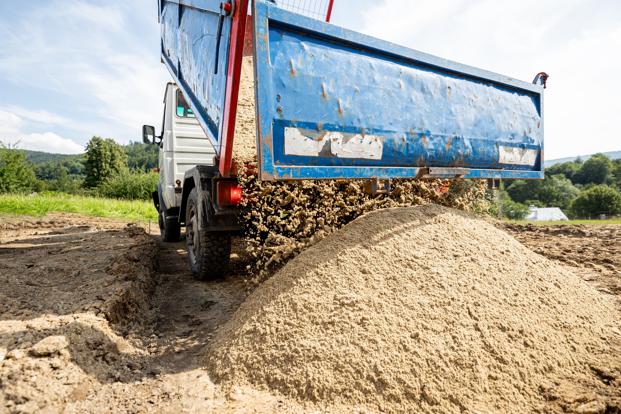 Unloading the truck with the soil and sand at construction site